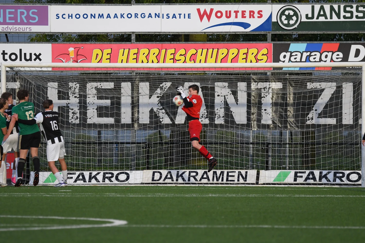 Wedstrijdmoment Achilles’29 met zichtbare sponsorborden